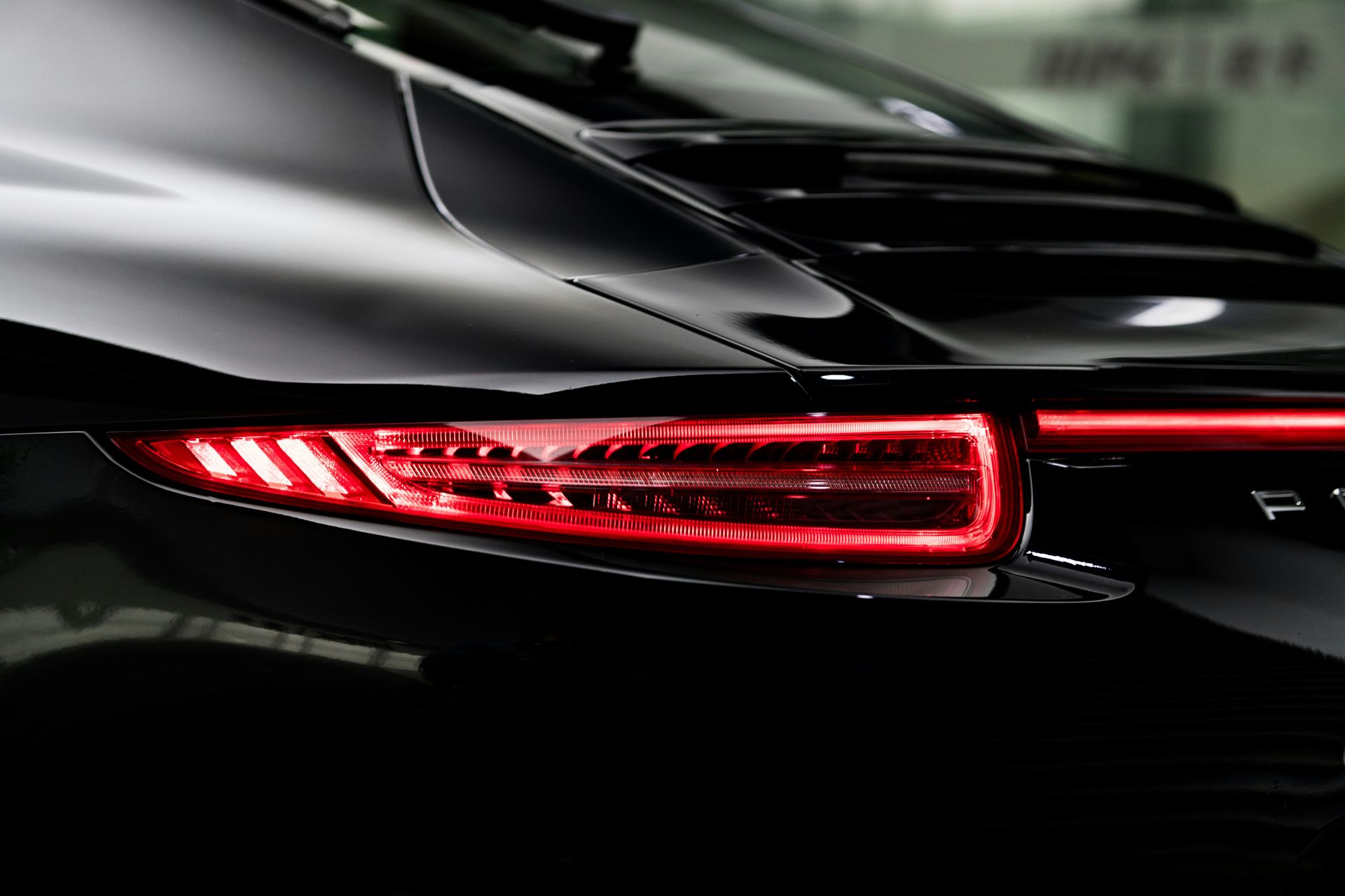 the tail lights of a black sports car