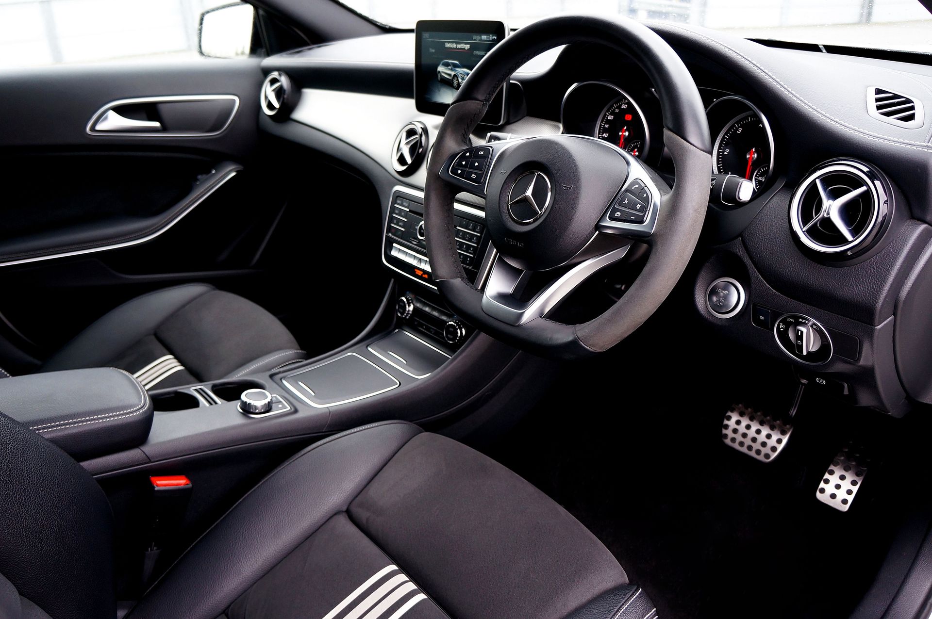Modern Mercedes car interior showcasing steering wheel, dashboard, and sleek design.